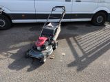 a lawn mower that is sitting in the parking lot