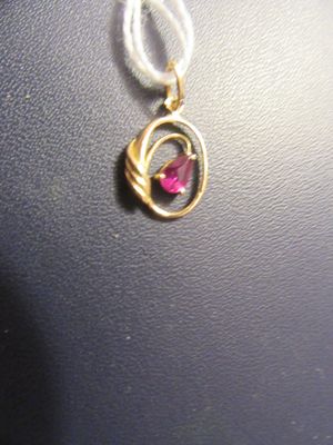 un collier en or orné d'une pierre rose