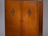une armoire ancienne en bois à deux portes, dont l'une est vitrée