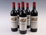 trois bouteilles de vin rouge sont alignées sur une surface blanche