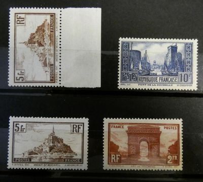 quatre timbres différents provenant de différents pays, exposés dans une vitrine