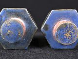 pair of blue and gold earrings on black surface with black background