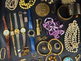 many different types of jewelry displayed on a black surface