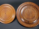 two wooden plates sitting on top of each other on a table