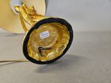 a gold and black lamp that is sitting on a table