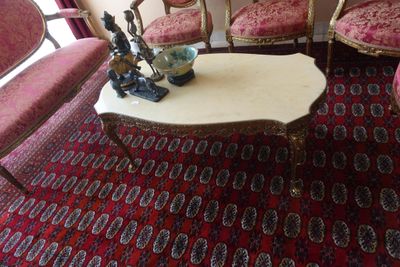 plusieurs chaises et une table dans une pièce recouverte d'un tapis rouge