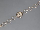 a close up of a wrist watch with a chain around it