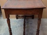 a small table with a wooden top on a cement floor