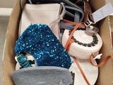 a box full of purses and handbags sitting on the floor