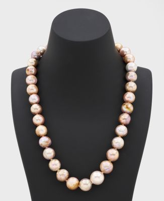 un collier de perles roses sur un mannequin, muni d'un fermoir en or