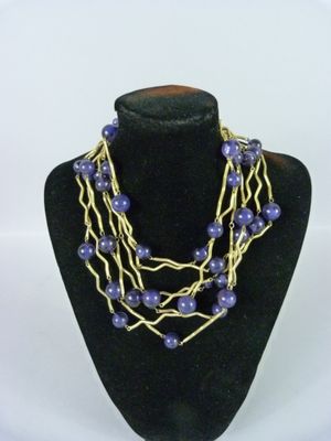 Collier composé de perles violettes et de fil d'or, présenté sur un mannequin