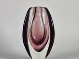 un vase noir et blanc posé sur une surface blanche