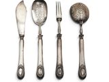 three spoons, a fork, and a spoon rest on a white surface