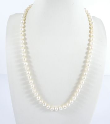 un gros plan d'un collier de perles blanches sur un mannequin