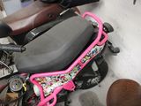 a pink scooter with a black seat and a pink handlebar