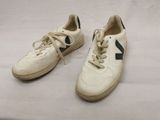 pair of white sneakers with green trims on a white surface