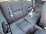the back seats of a car with a remote control in the passenger seat