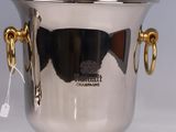 a silver ice bucket with gold handles on a white table