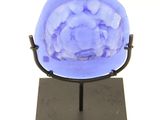a small blue object on a black stand on a white background