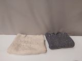pair of knitted purses sitting on a table in front of a wall