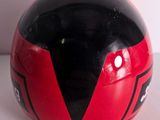 a red and black helmet sitting on a white surface