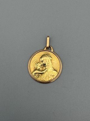 une médaille d'or sur laquelle est représenté le visage d'un homme