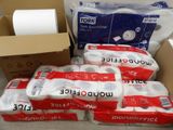 several rolls of toilet paper are stacked on top of a cardboard box