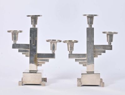 two silver candlesticks that are sitting on a table