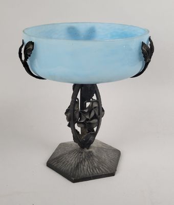 un bol en verre bleu posé sur un socle en métal