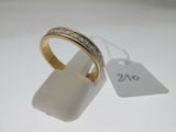 gros plan d'une bague en or avec des diamants sur une surface blanche