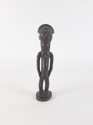 wooden statue of a man with a hat on his head and hands on his hips