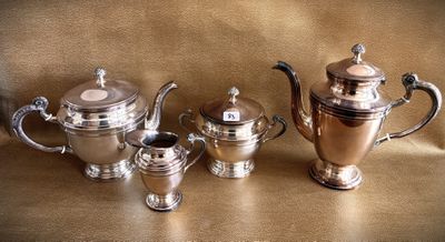 three silver teapots and two silver cups on a table