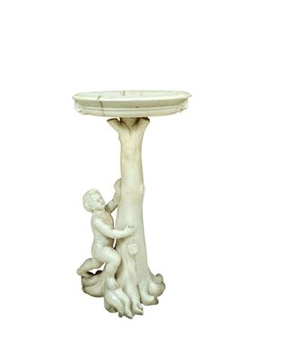 a statue of a boy and a girl sitting on a birdbath