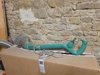 une boîte sur laquelle est posé un sèche-cheveux, à côté d'un mur de briques