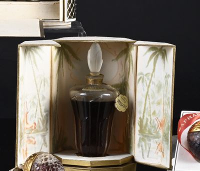 a bottle of liquor sitting in a box next to a box with a figurine inside of it