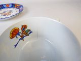 a white plate with a flower on it next to a blue and white plate with a flower on it