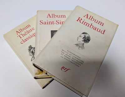 trois livres sont empilés sur une table