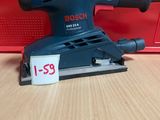 La ponceuse orbitale Bosch se trouve sur une table, à côté d'une boîte rouge.