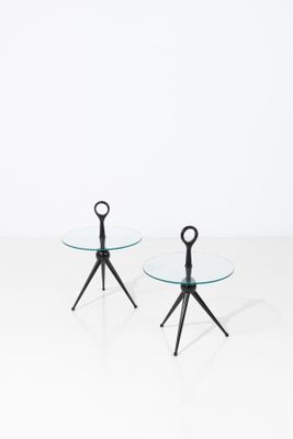 une paire de tables en verre avec des pieds noirs et un plateau blanc