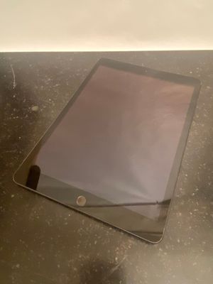une tablette posée sur une table recouverte d'une vitre