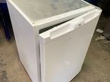 a white refrigerator sitting in the middle of a room