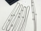 a group of silver necklaces and a wallet on a table