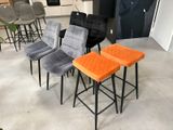 Plusieurs chaises et tabourets sont alignés dans une pièce
