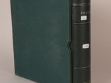 an old book with a green cover sitting on top of a table