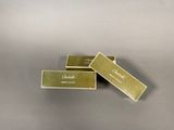 three gold business cards sitting on top of each other on a table