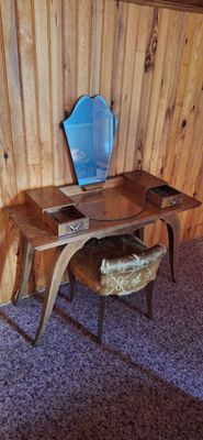 a desk with a chair and a mirror in the corner of the room