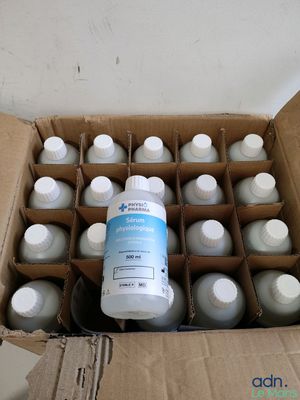 a cardboard box filled with bottles of water and a bottle of liquid