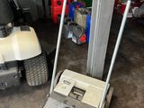 une tondeuse à gazon et un chariot pour tondeuse dans un garage