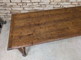 a wooden table that is sitting in front of a brick wall