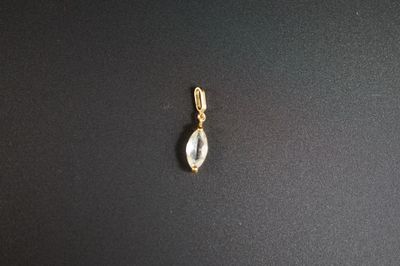 un gros plan d'un pendentif plaqué or orné d'un quartz transparent